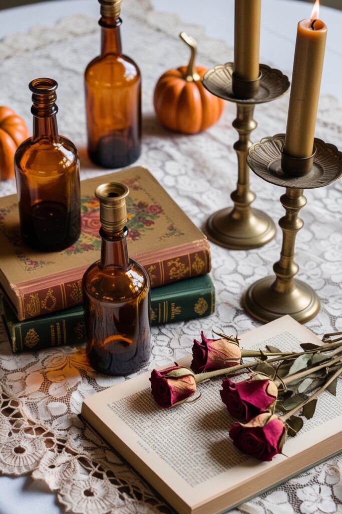 Flat lay featuring vintage amber glass bottles, old romantic books, brass candlesticks, and dried roses